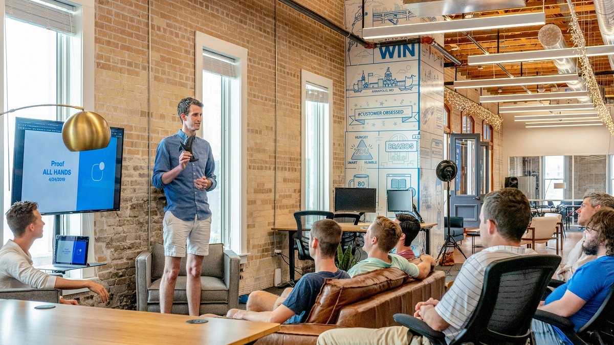 A presenter sharing ideas with a small seated audience in an informal workshop